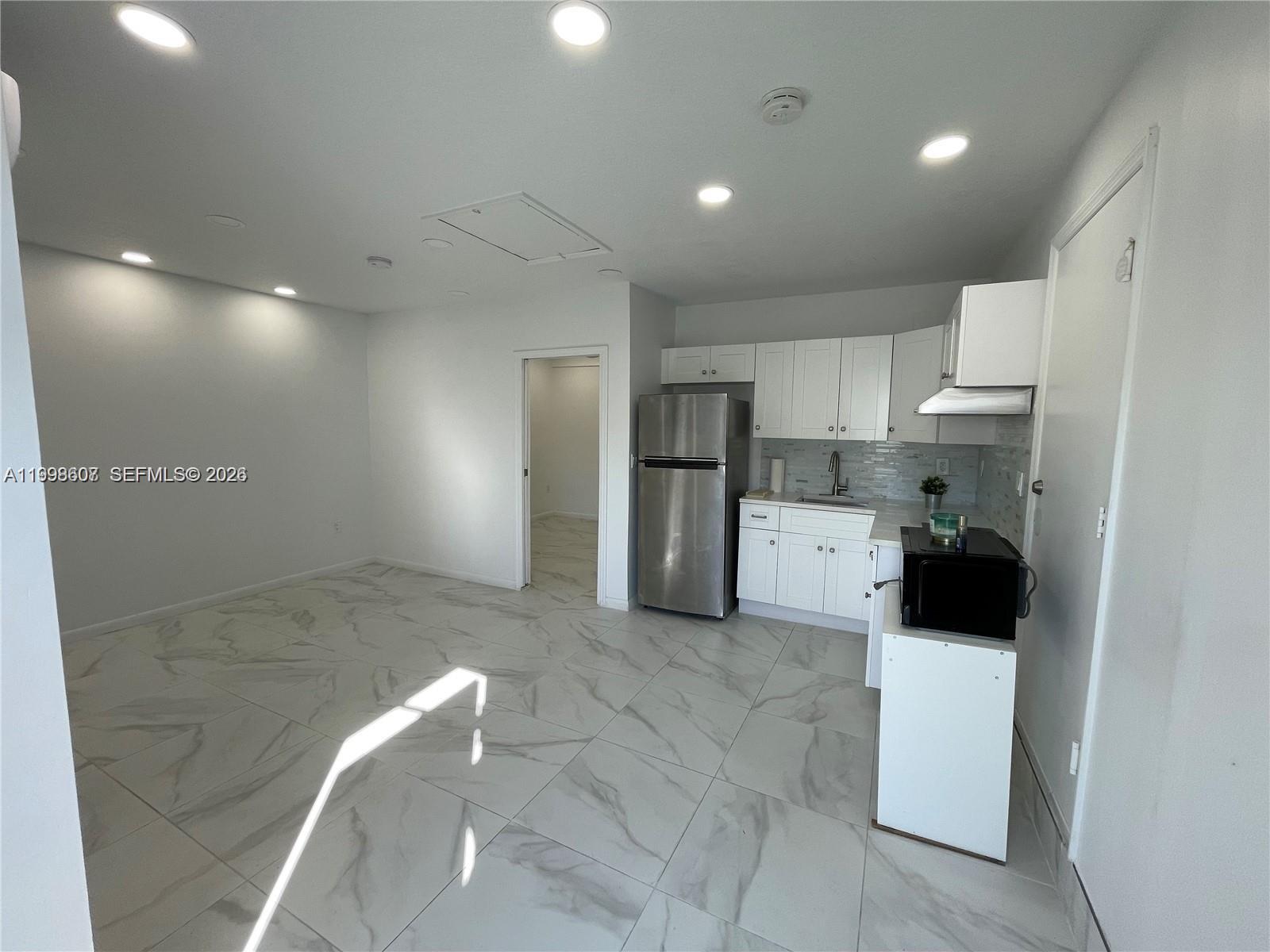 3403 Southwest 150th Court, Unit 1 Miami, FL 33185 - Photo 3 of 6 a view of a kitchen with a sink and refrigerator
