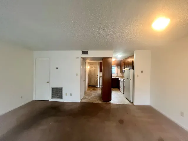 an empty room with a window and a ceiling fan