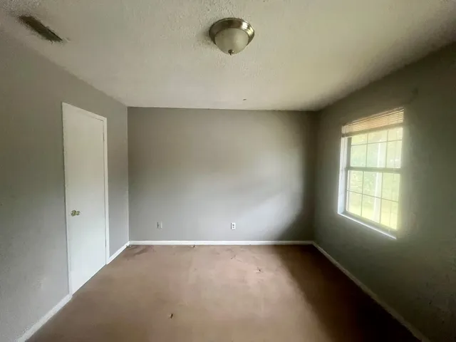 an empty room with a empty space and windows