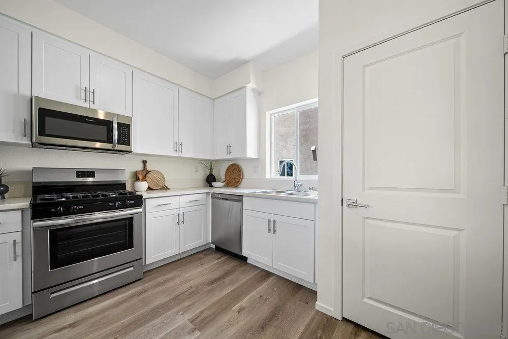 8188 Golden Avenue Lemon Grove, CA 91945 - Photo 12 of 47 a kitchen with appliances cabinets and a wooden floor