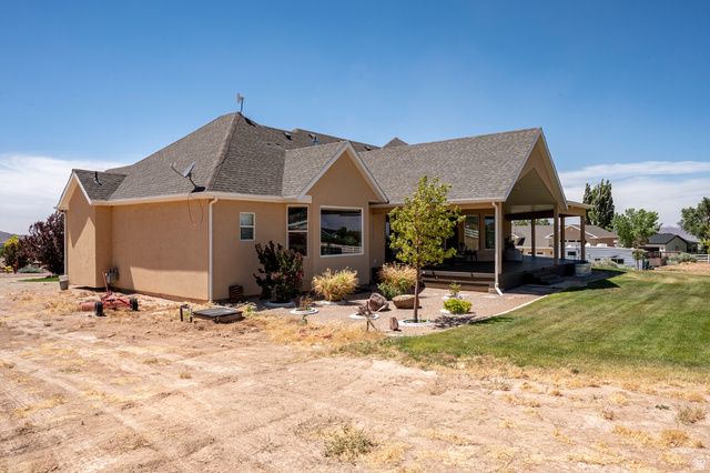 3311 West Allard Summit, UT 84772 - Photo 85 of 97 Rear exterior featuring a covered patio, stucco siding, a composition shingle roof, large windows, and a landscaped patio area