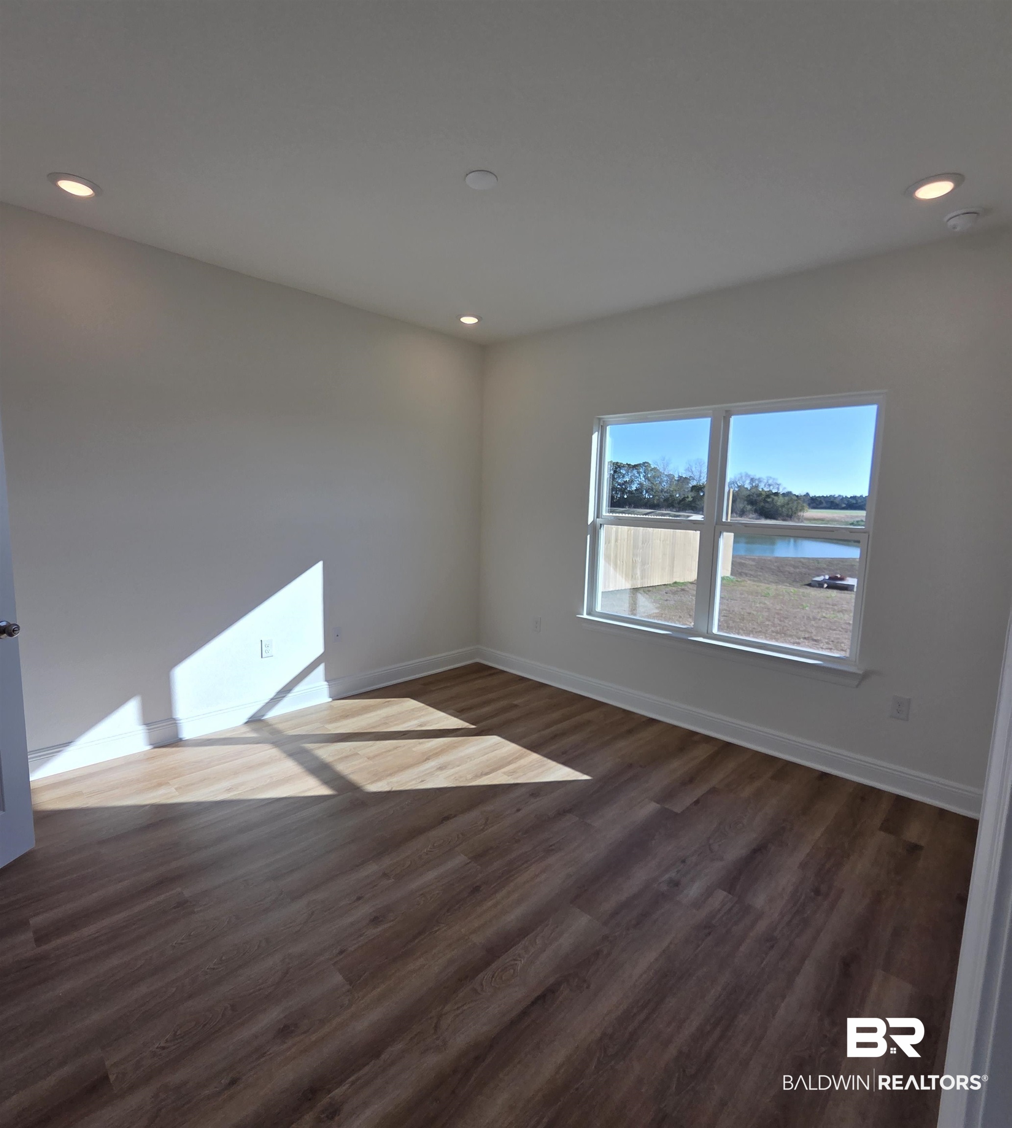 28084 Hallow Trail Elberta, AL 36530 - Photo 8 of 21 Unfurnished room featuring dark wood-type flooring, a water view, and recessed lighting