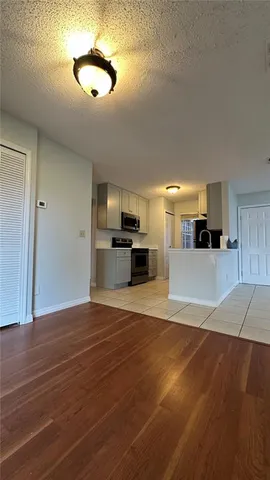 a view of a kitchen with a sink stove refrigerator and cabinets