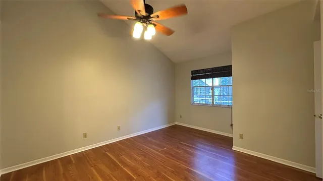 an empty room with a window and wooden floor