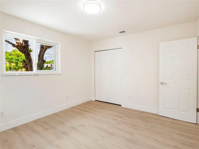 an empty room with windows and with wooden floor