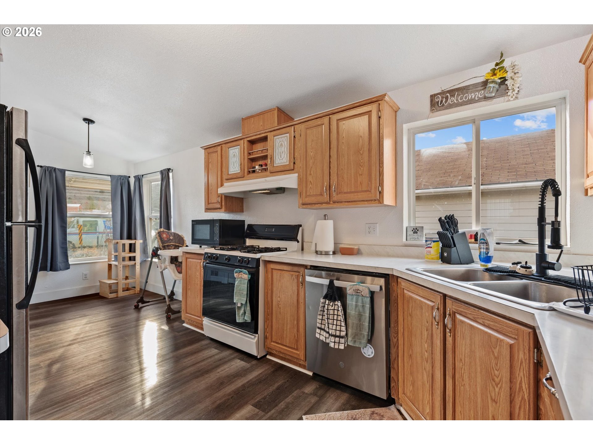2106 Colorado Place Baker City, OR 97814 - Photo 25 of 40 a kitchen with stainless steel appliances granite countertop a refrigerator a sink dishwasher a stove and white countertops with wooden floor