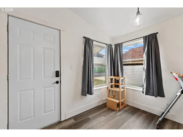a living room with hardwood floor and cabinet