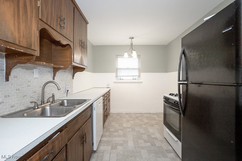 4815 Redfern Road Parma, OH 44134 - Photo 6 of 22 Kitchen featuring light countertops, a sink, freestanding refrigerator, white dishwasher, and range with gas stovetop