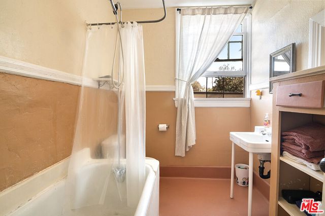 a view of a hallway with wooden floor and a cabinet