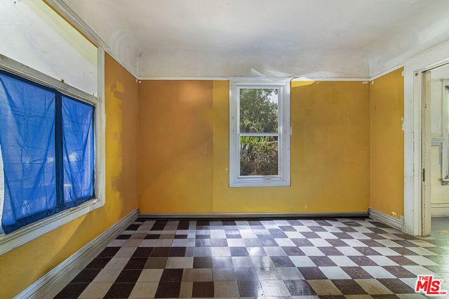 a view of a livingroom with furniture wooden floor fireplace and windows