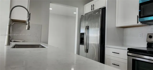 a kitchen with a refrigerator and a stove top oven