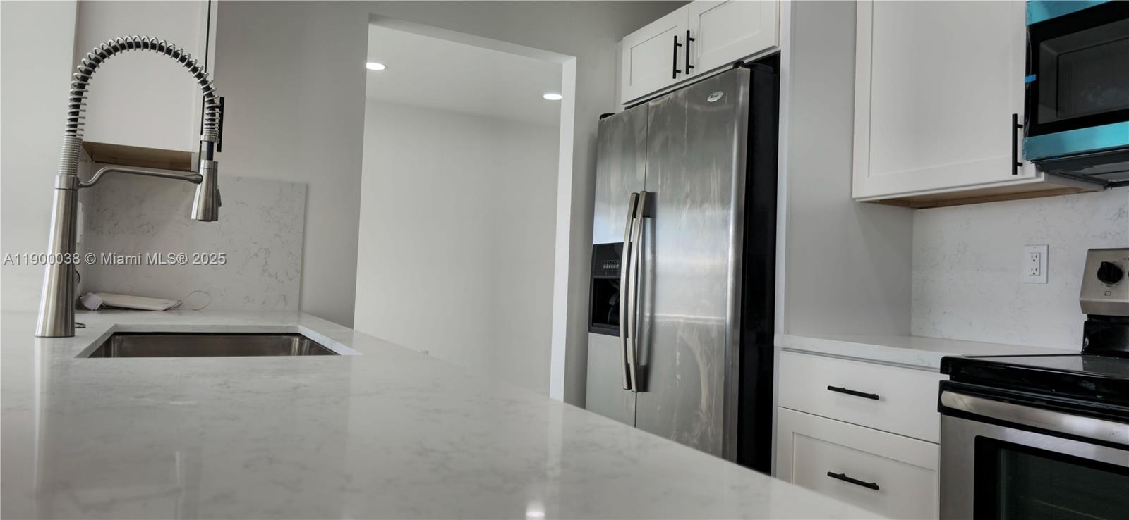 4404 Northwest 46th Way, Unit 4404 Tamarac, FL 33319 - Photo 14 of 27 a kitchen with a refrigerator and a stove top oven