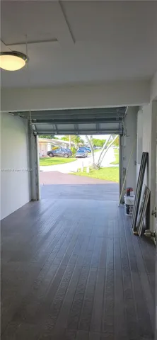 a view of a room with wooden floor and a sink