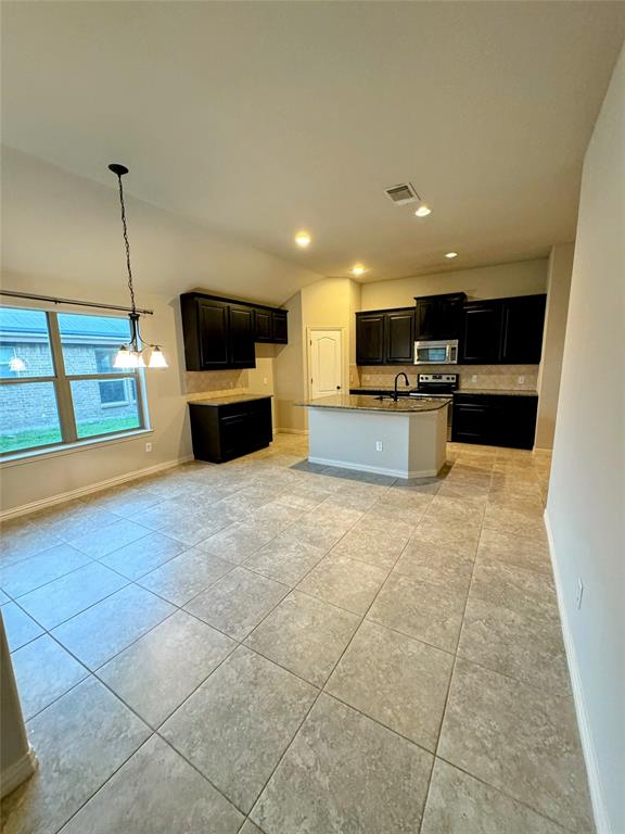 236 Archer Way Forney, TX 75126 - Photo 7 of 35 a large kitchen with stainless steel appliances a stove a sink a microwave and a refrigerator