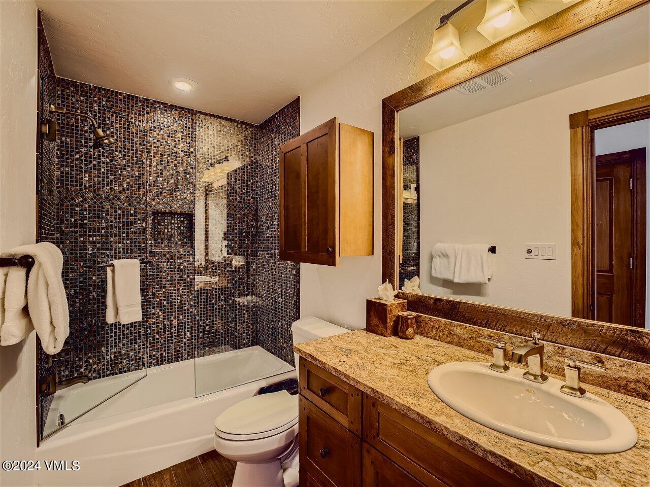 62 Highlands Lane, Unit R306 Beaver Creek, CO 81620 - Photo 20 of 32 a bathroom with a granite countertop sink a toilet a mirror and bathtub