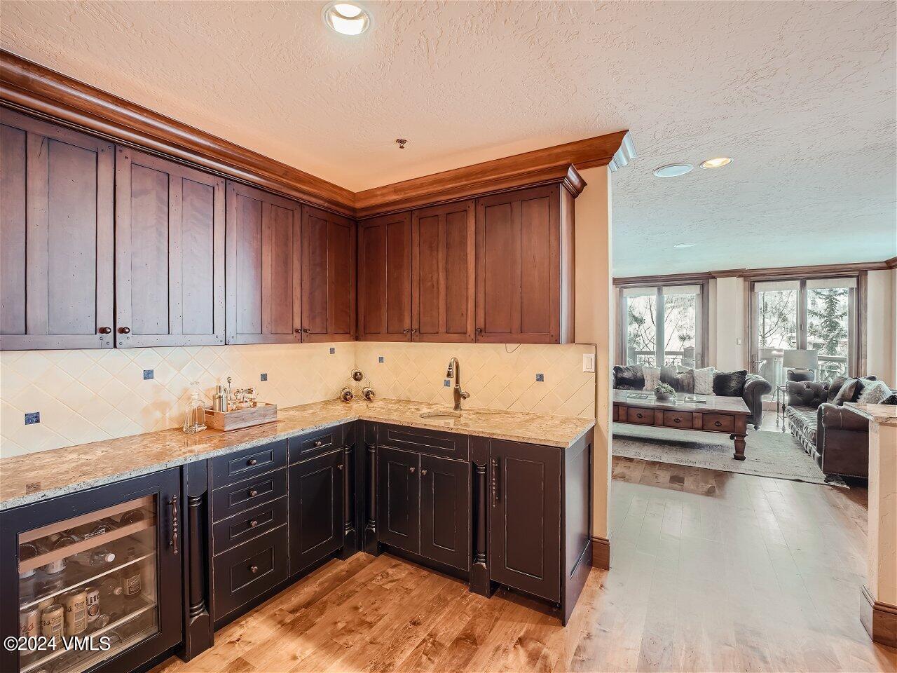 62 Highlands Lane, Unit R306 Beaver Creek, CO 81620 - Photo 7 of 32 a kitchen with a sink and wooden cabinets
