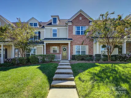 a front view of a house with yard and green space
