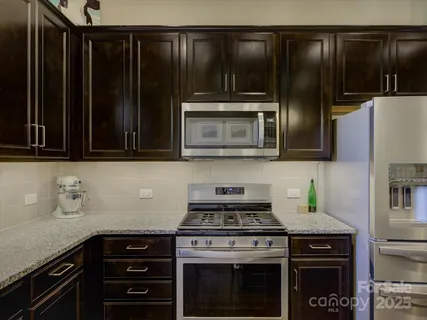 a kitchen with granite countertop stainless steel appliances granite countertop wooden cabinets and a granite counter tops