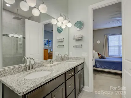 a bathroom with a granite countertop sink a large mirror and a shower