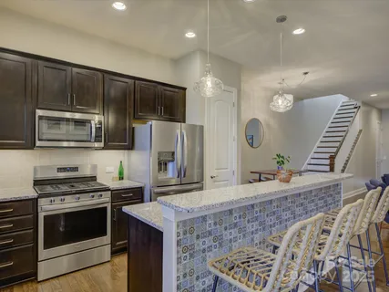 a kitchen with stainless steel appliances granite countertop a stove a sink a refrigerator and a microwave