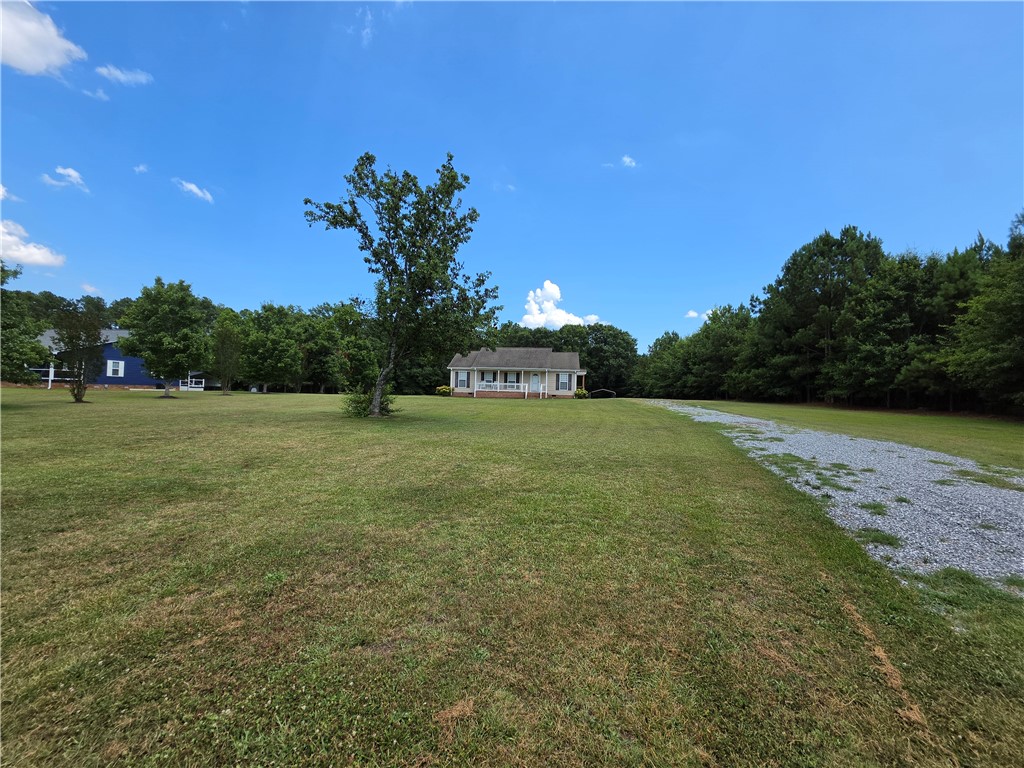 325 McAdams School Road Honea Path, SC 29654 - Photo 2 of 22 A tranquil rural setting with a neatly kept yard leading to a charming residence amidst lush trees.