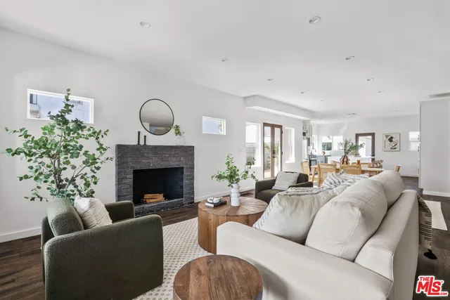 a living room with furniture a fireplace and a potted plant