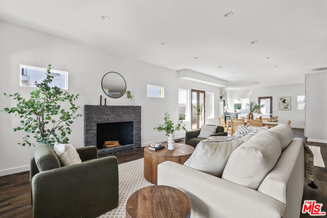 a living room with furniture a fireplace and a potted plant