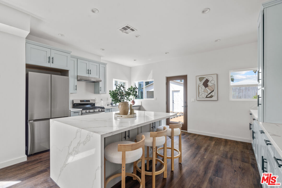 2209 West Boulevard Los Angeles, CA 90016 - Photo 11 of 29 a kitchen with stainless steel appliances granite countertop a refrigerator and a stove top oven