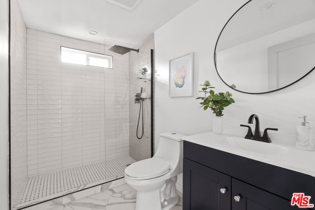 2209 West Boulevard Los Angeles, CA 90016 - Photo 18 of 29 a bathroom with a sink a toilet and a mirror