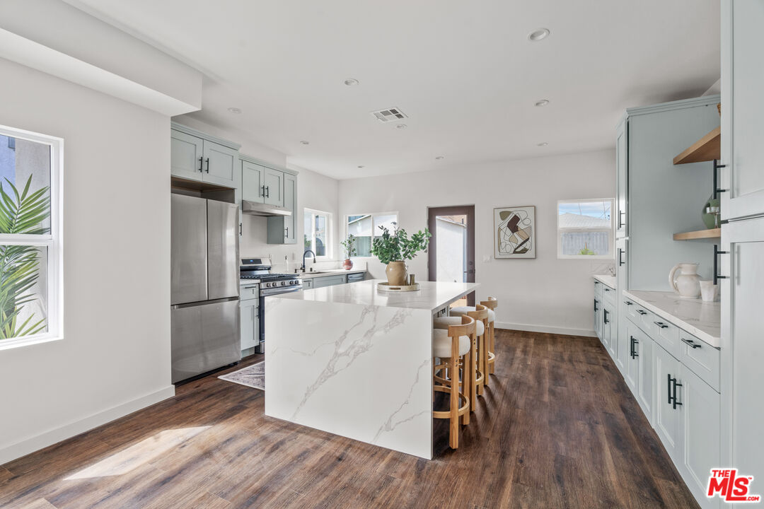 2209 West Boulevard Los Angeles, CA 90016 - Photo 10 of 29 a kitchen with white cabinets and stainless steel appliances