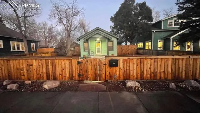 a view of a house with wooden fence