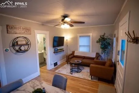 a living room with furniture a flat screen tv and a window