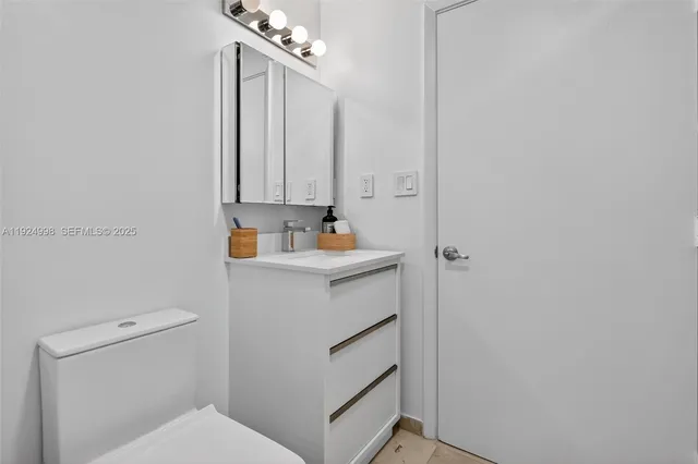 a bathroom with a toilet sink and cabinets