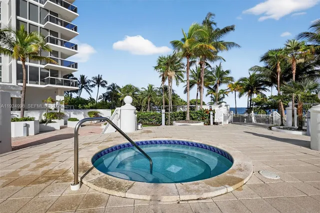 a view of a basketball court with palm trees