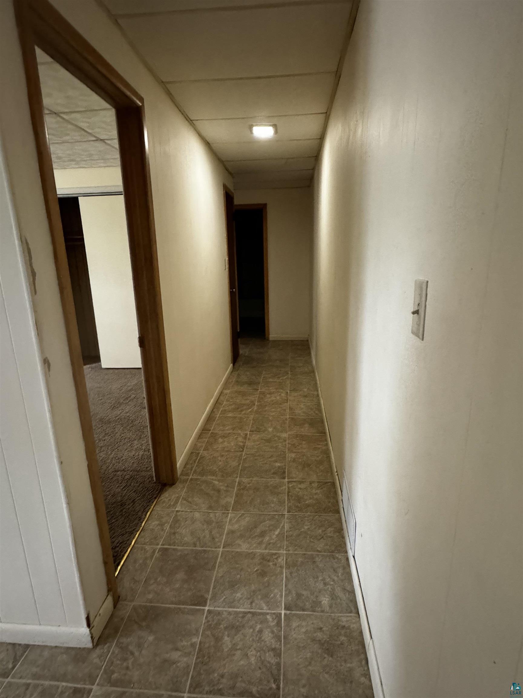 Hallway with tile flooring