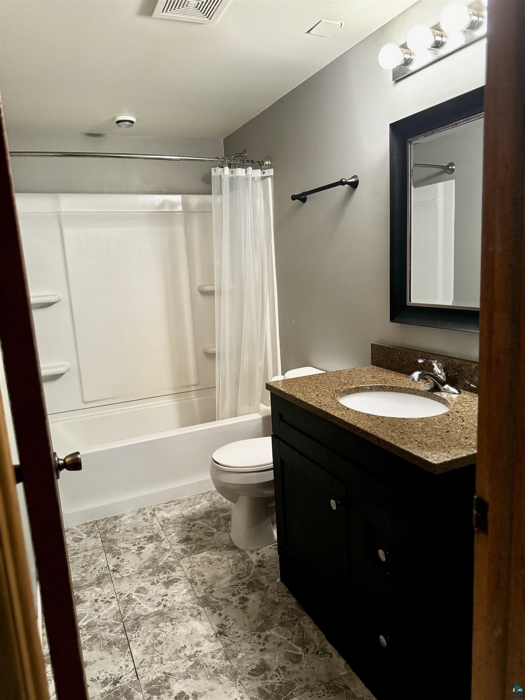 9039 Biller Loop Solon Springs, WI 54873 - Photo 9 of 17 Full bathroom with oversized vanity, toilet, tile floors, and shower / tub combo