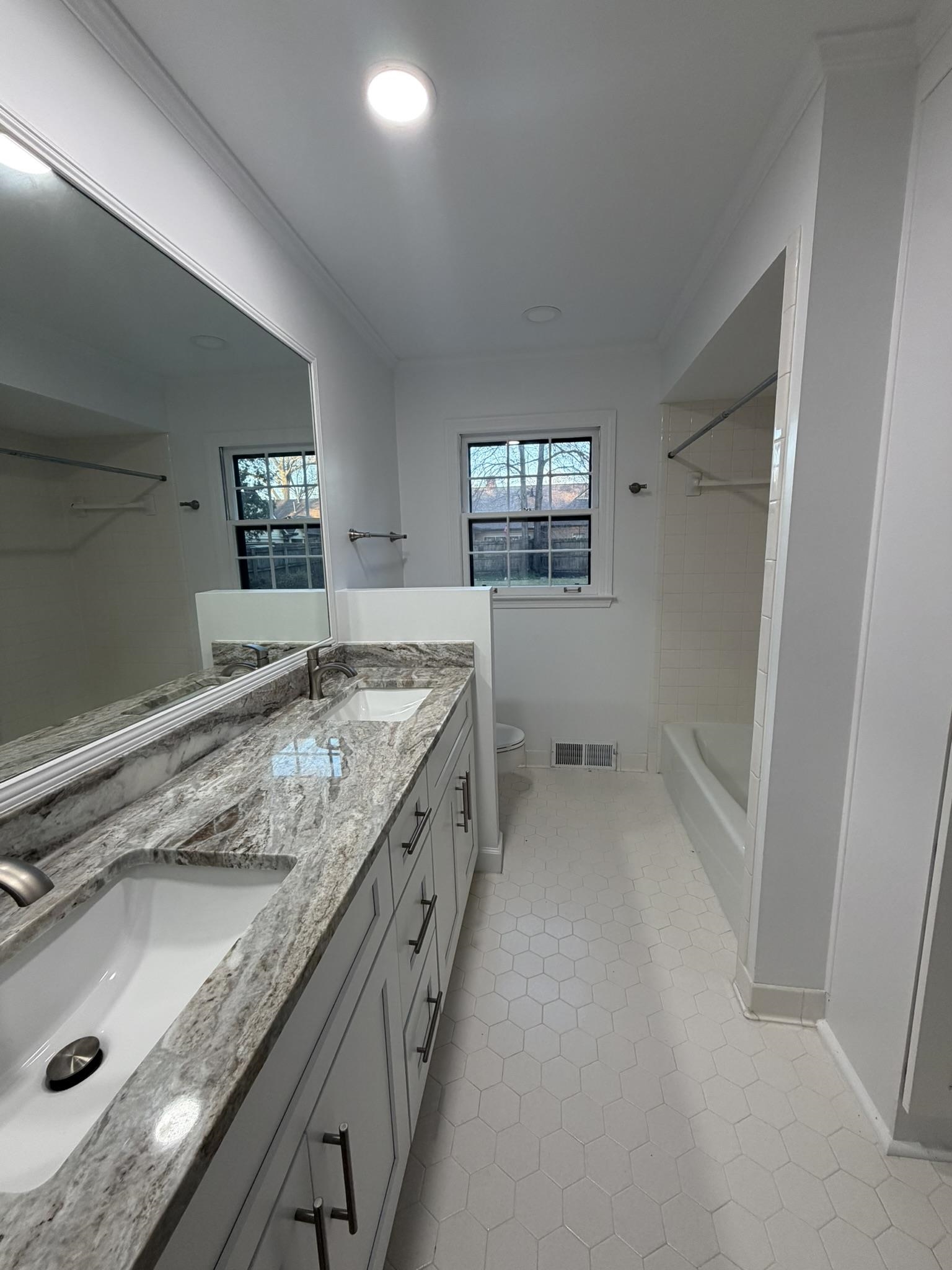 2960 South Germantown Road Germantown, TN 38138 - Photo 21 of 36 a bathroom with a granite countertop sink a mirror and a bathtub