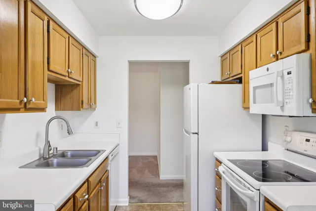 a kitchen with a sink a refrigerator and cabinets