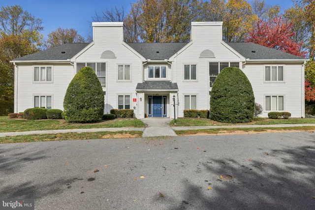 a front view of a house with a yard and trees