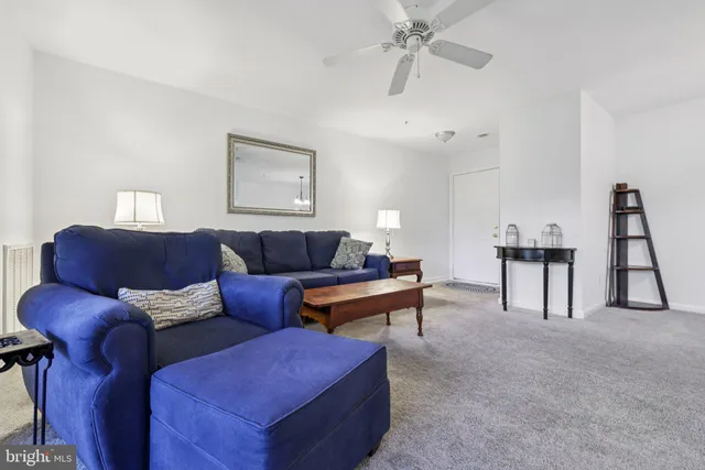 a living room with furniture and a ceiling fan