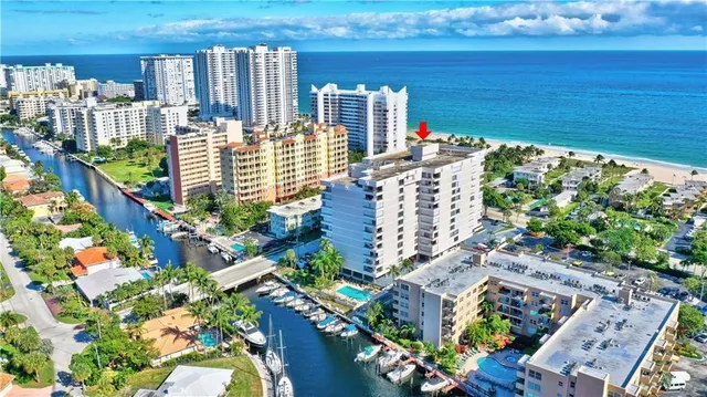 a view of a building with a yard and large parking space