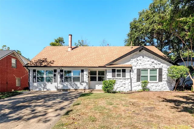 a view of a house with a yard and potted plants