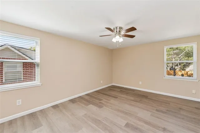 a view of an empty room with a window and a fan
