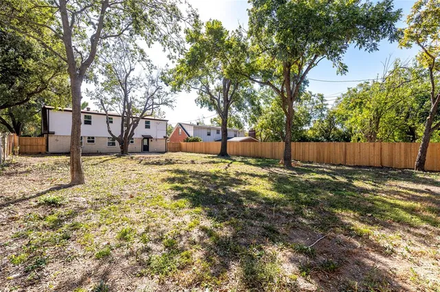 a backyard of a house with table and chairs