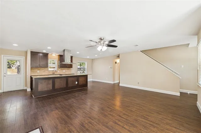 a kitchen with stainless steel appliances a sink cabinets and wooden floor