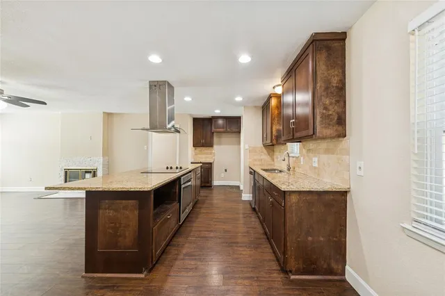 a large kitchen with stainless steel appliances a sink and cabinets