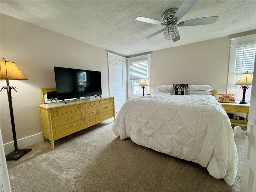 1160 6th Street Beaver, PA 15009 - Photo 14 of 31 a bedroom with a bed tv and a chandelier