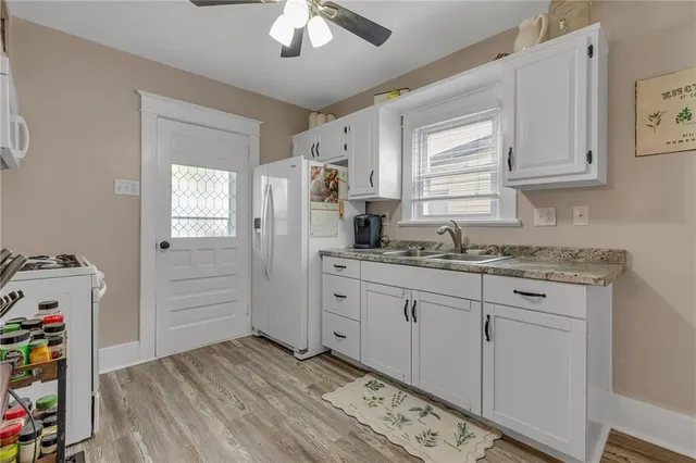 a kitchen with stainless steel appliances granite countertop a sink cabinets and wooden floor