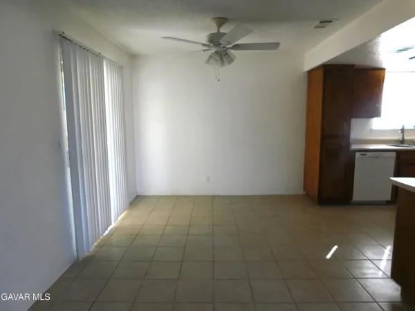 an empty room with a fireplace and a ceiling fan