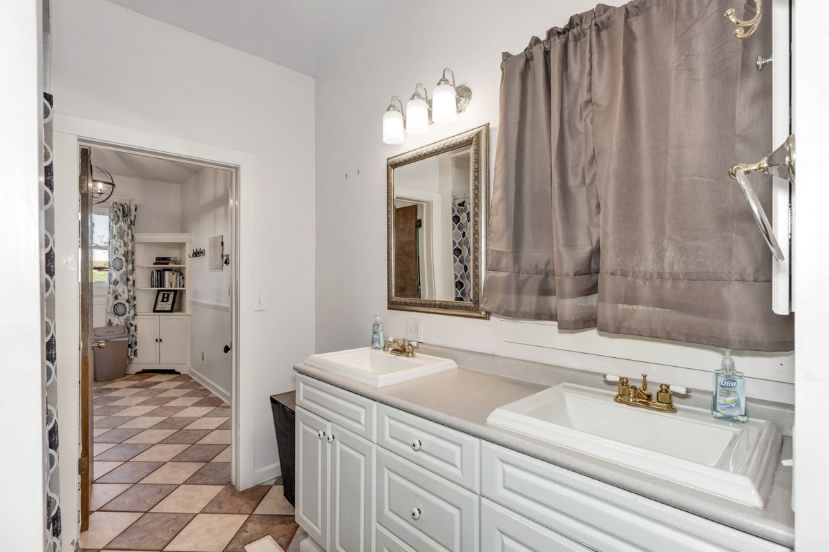 451 Wheelerton Road Dellrose, TN 38453 - Photo 16 of 34 a bathroom with double vanity sink a mirror and a bathtub